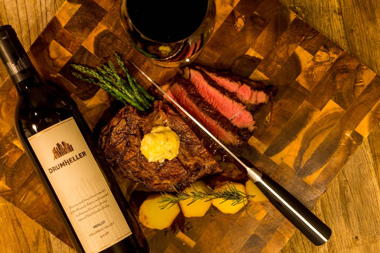 A delicious steak served with roasted rosemary potatoes and a glass of Drumheller's Merlot wine in Drumheller's Food and Drink in Richland, Washington.