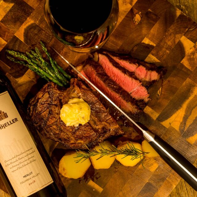 A delicious steak served with roasted rosemary potatoes and a glass of Drumheller's Merlot wine in Drumheller's Food and Drink in Richland, Washington.