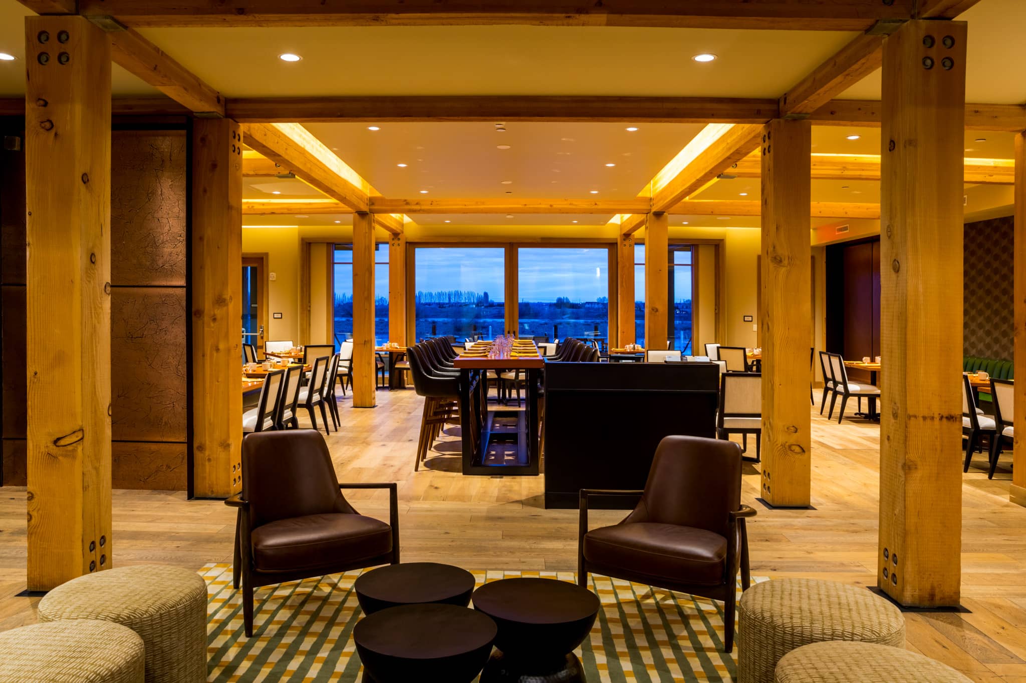 Interior shot of Drumheller's Food and Drink, a riverfront restaurant in Richland, Washington, with romantic lighting and a view of the evening outside.
